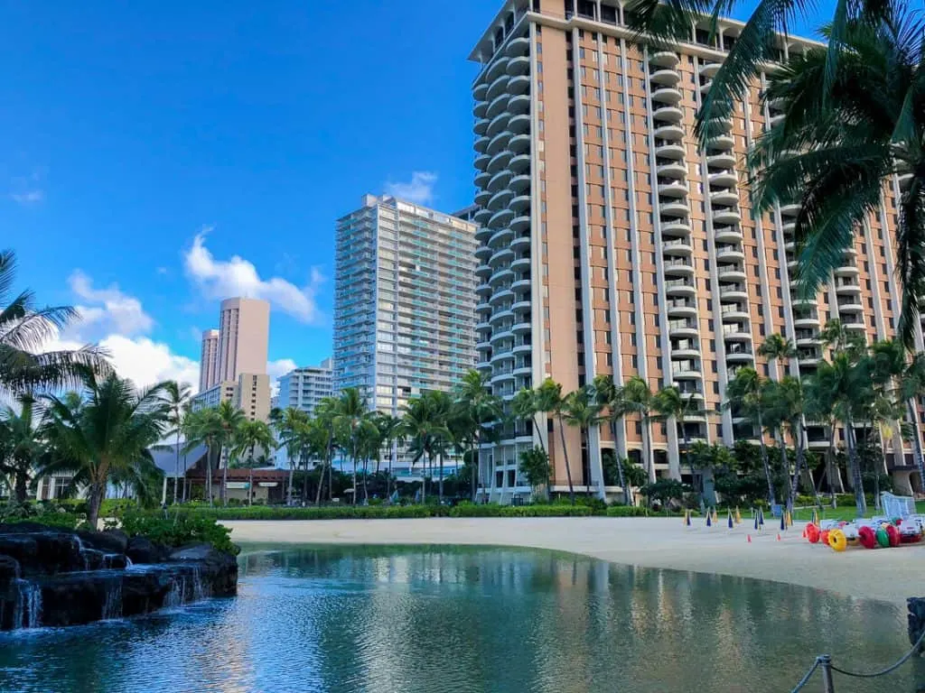 Tall buildings in Oahu next to body of water.