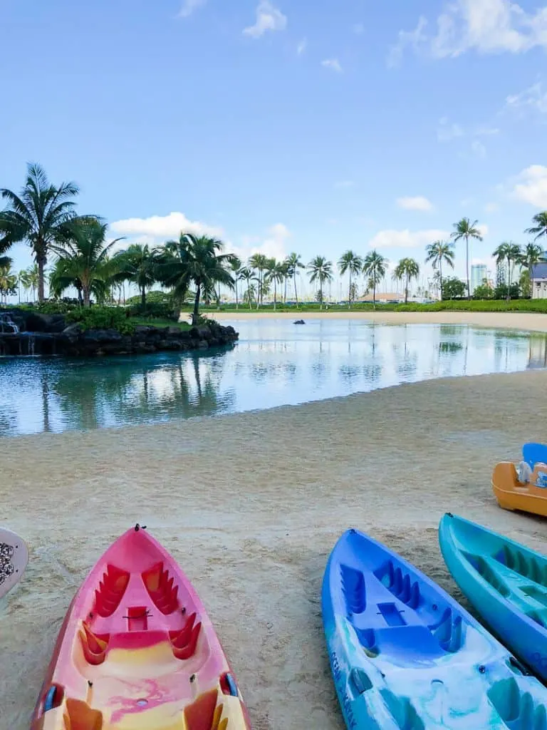 Canoes sitting next to body of water in Oahu.