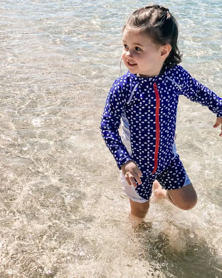 Girl plays in ocean at Hawaii family beach.