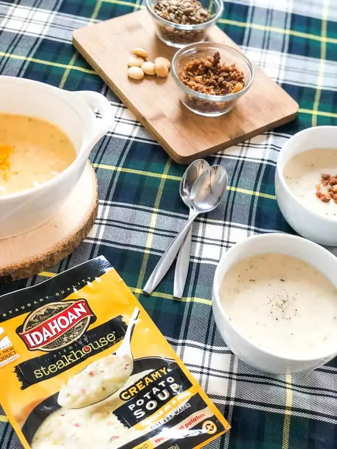 Bowls of soup next to toppings and spoons.