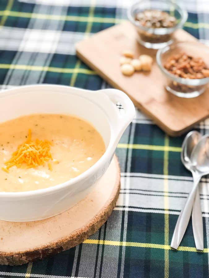 Cheesy soup on table with spoons.