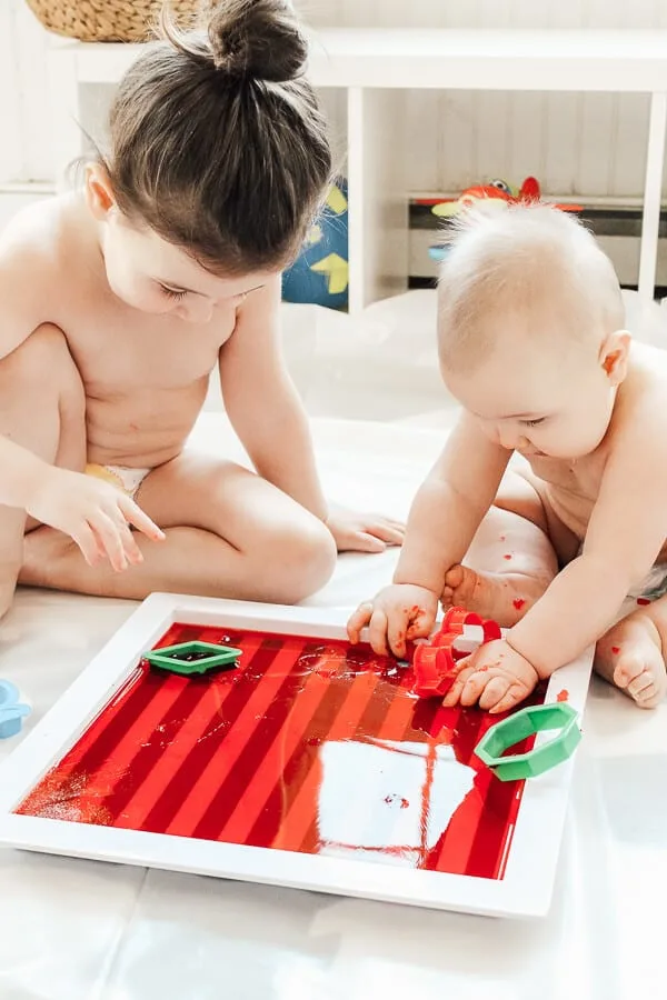 Children play with Jello on tray.