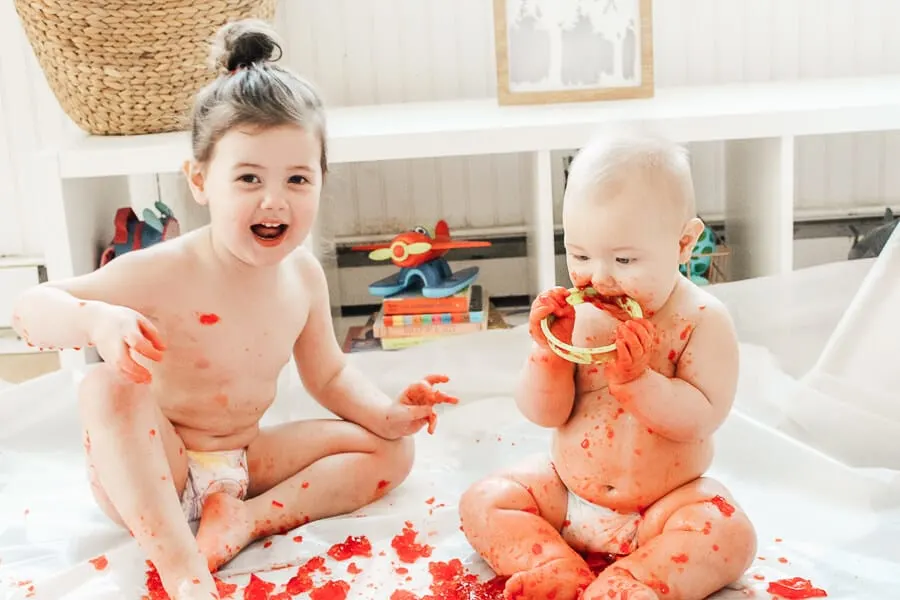 Children use play tools to interact with red Jello.