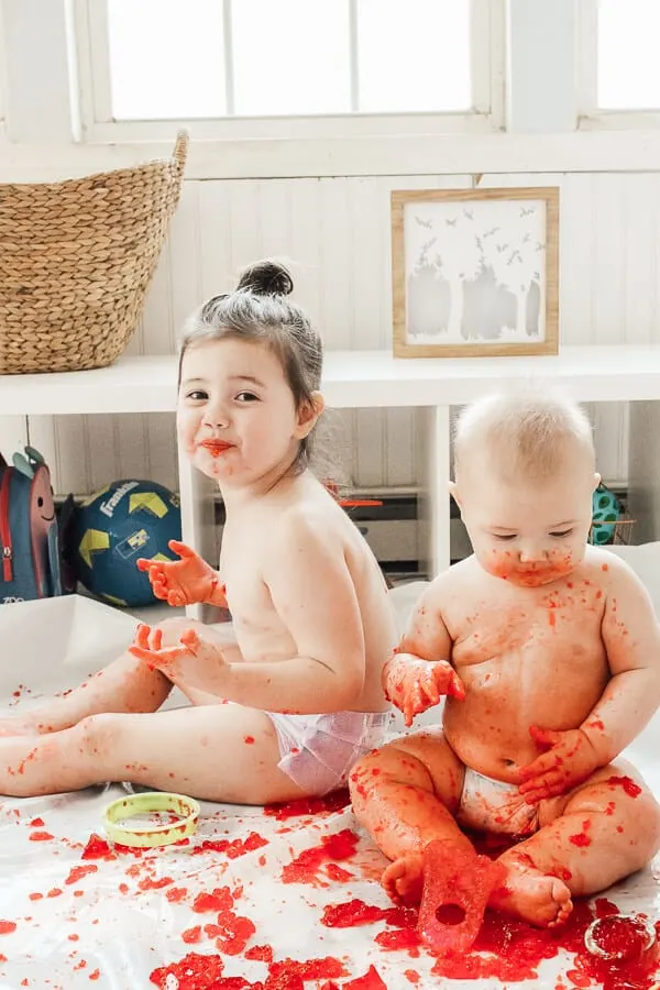 Children engage in sensory play with red Jello.