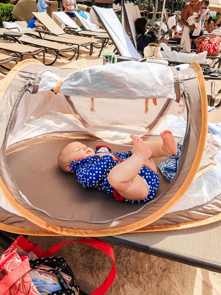 Baby lays in tent at Disney park resort.