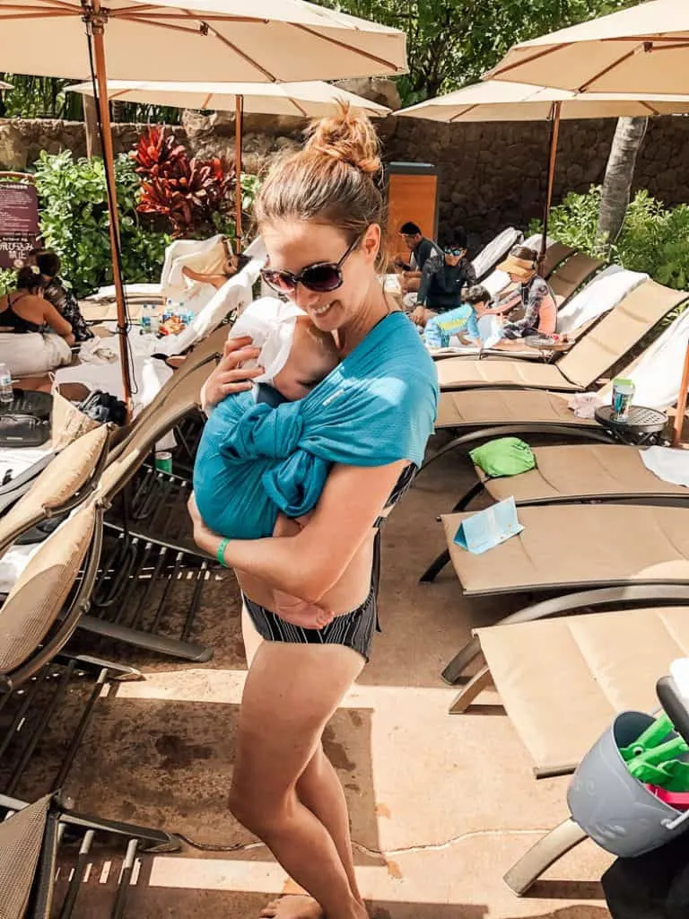 Mom holds baby by pool at Hawaii Disney resort.