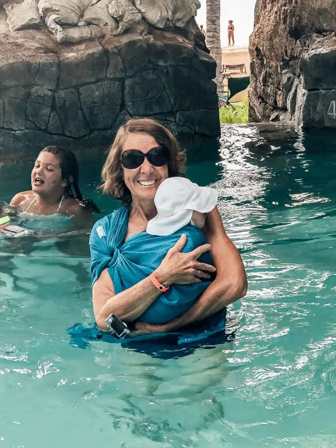 Woman holds child in Disney water park pool.