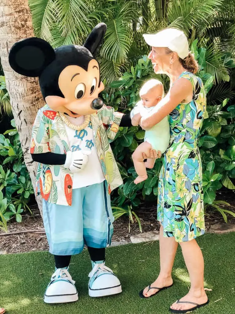 Mom introduces baby to Mickey Mouse at Hawaii resort.