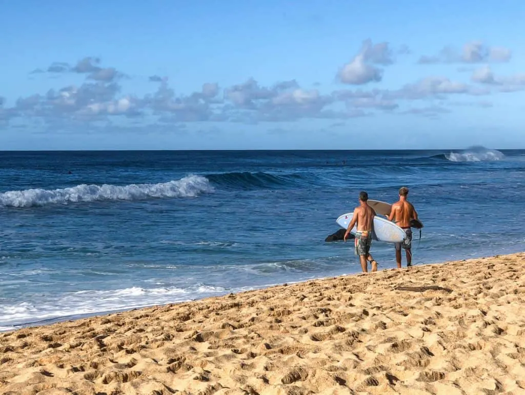 Surfers on beach in North Shore Hawaii.