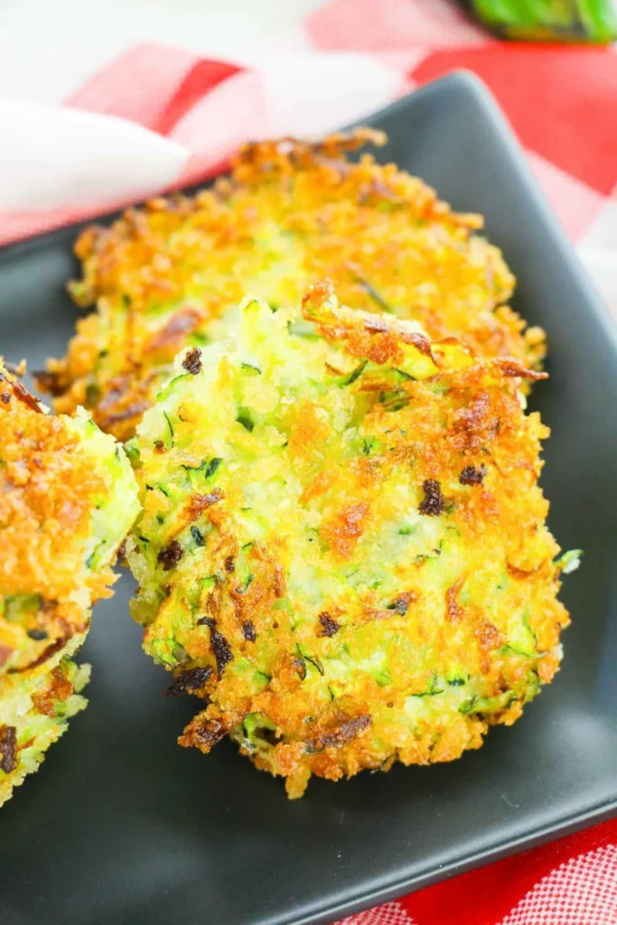 Zucchini fritters on a gray serving platter.