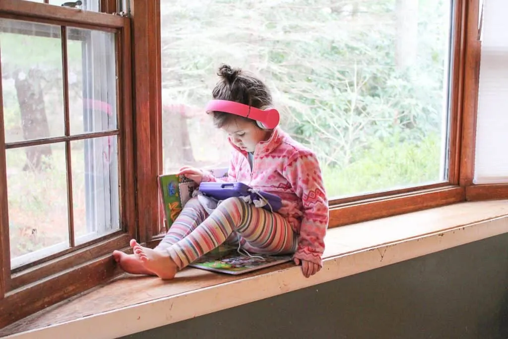 Toddler girl using tablet with headphones