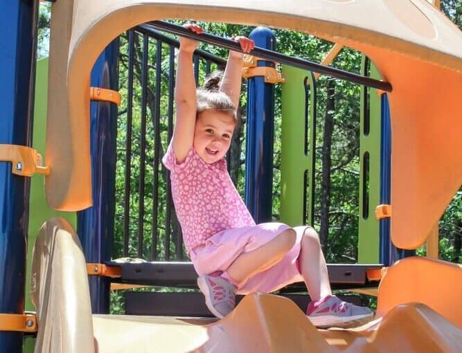Girl child plays on playground.
