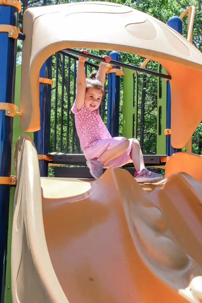 Child plays at the top of a slide.