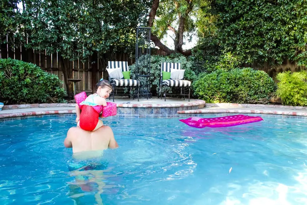 child and adult swimming in pool