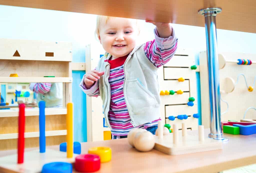 toddler playing with wooden montessori toys