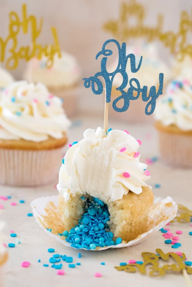 A Cupcake with blue sprinkles spilling out and a topper that says "Oh Boy".