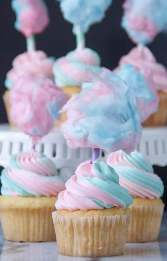Cotton Candy cupcakes with pink and blue swirled frosting and cotton candy on top.