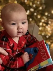 Baby holds Sesame Street fabric baby book.