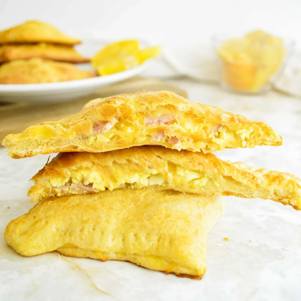 A stack of ham, egg, and cheese crescent roll breakfast pockets.
