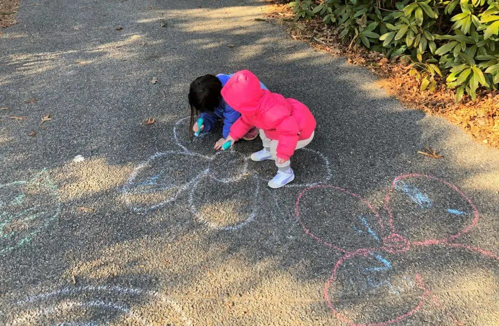 Children use chalk to draw on concrete for a fun birthday activity at home.