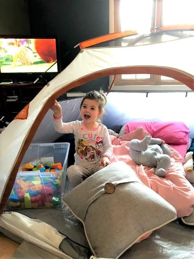 Little girl celebrates birthday at home in tent.