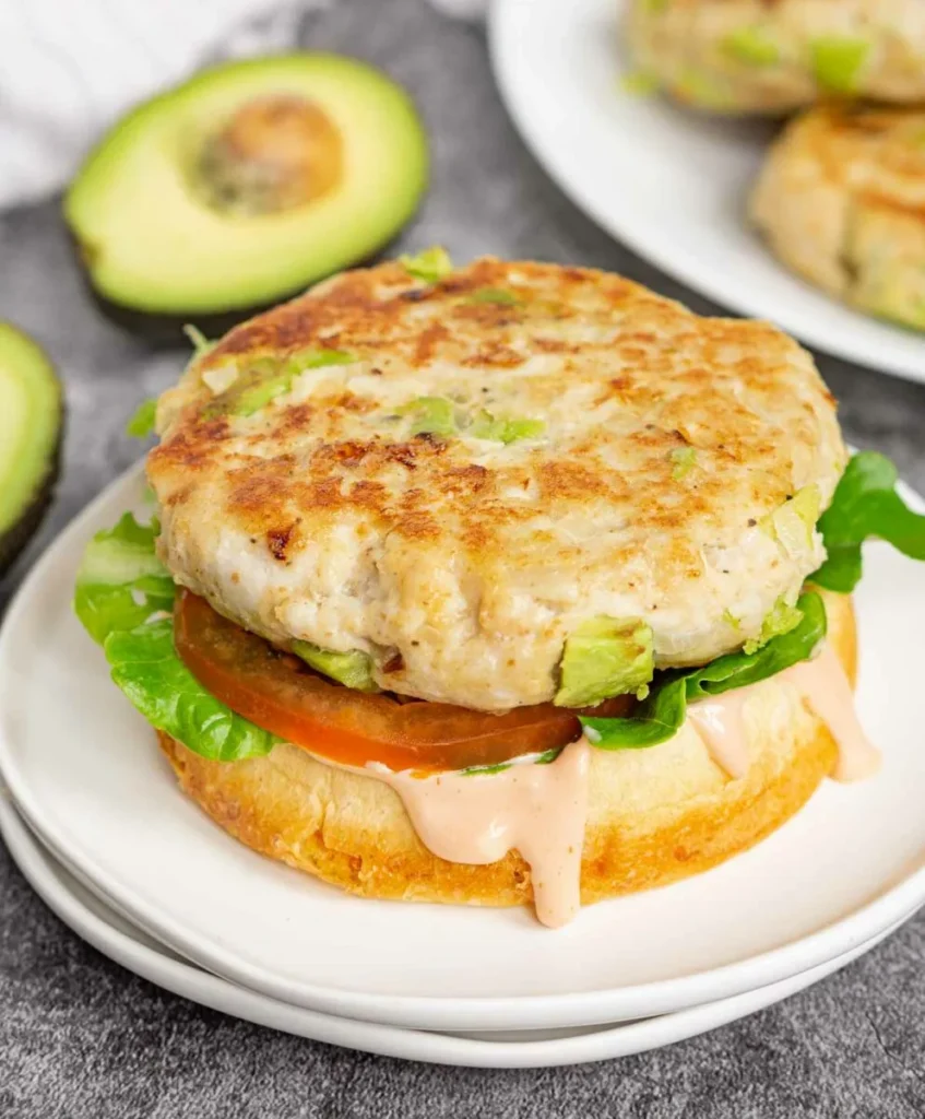 Chicken avocado burger with tomato, lettuce, and homemade burger sauce.