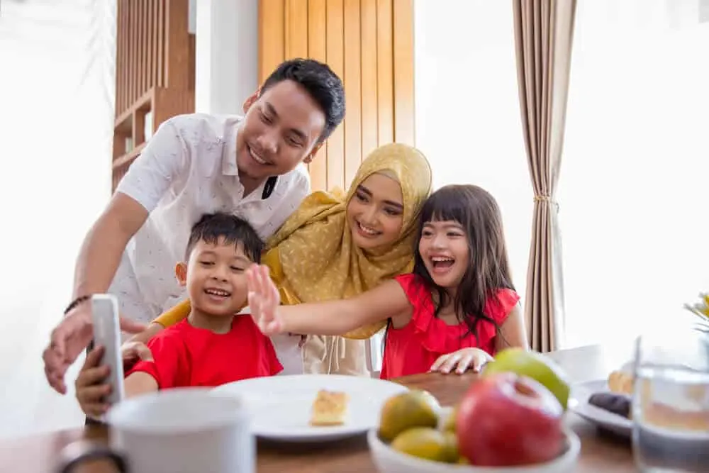 Family shares birthday celebration using a cellphone.