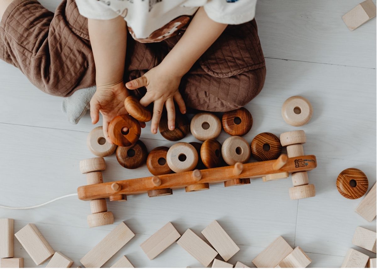 A toddler plays with wooden Montessori toys.
