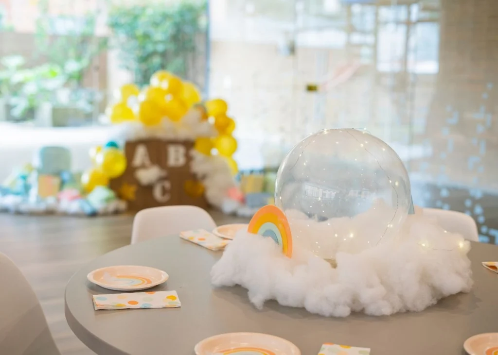 A rainbow and cloud centerpiece on a party table.