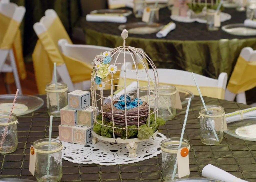 A bird cage centerpiece on a party table.