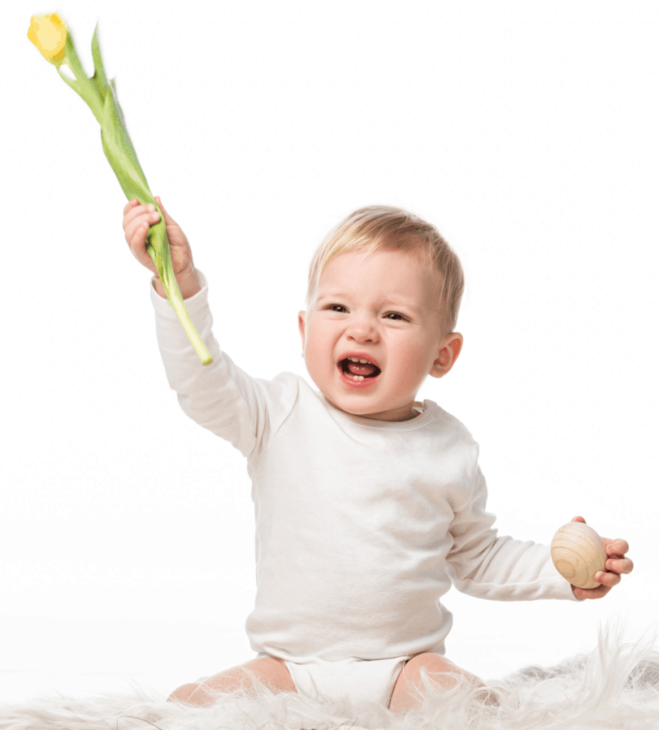 Baby boy holds up flower to represent flower inspired boy names.