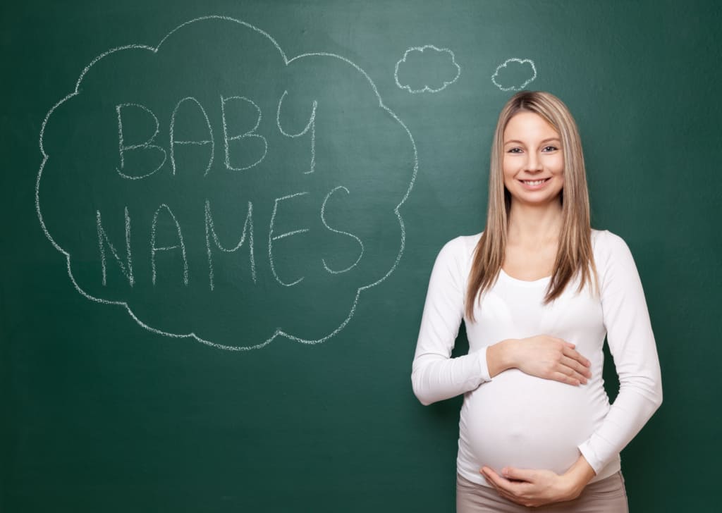 Mom holds baby bump and thinks of French names for girls.