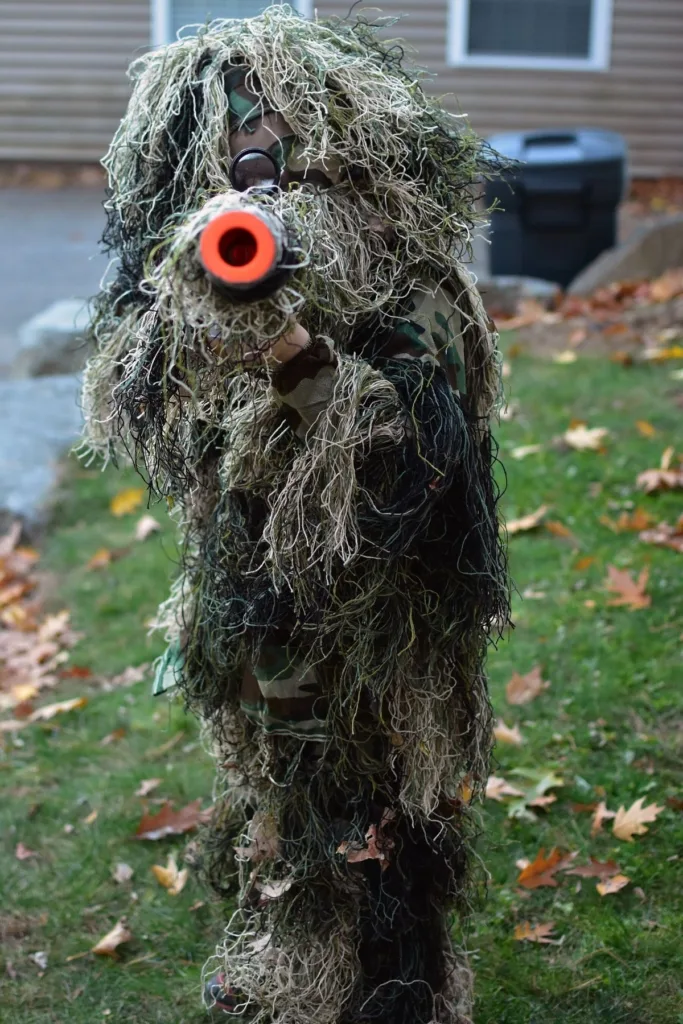 A young person dressed in a Gilly suit for Halloween outside.