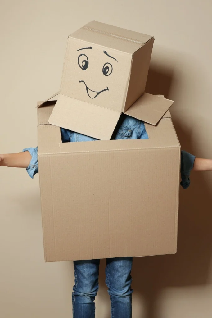 A young girl in a cardboard costume over her body and head.