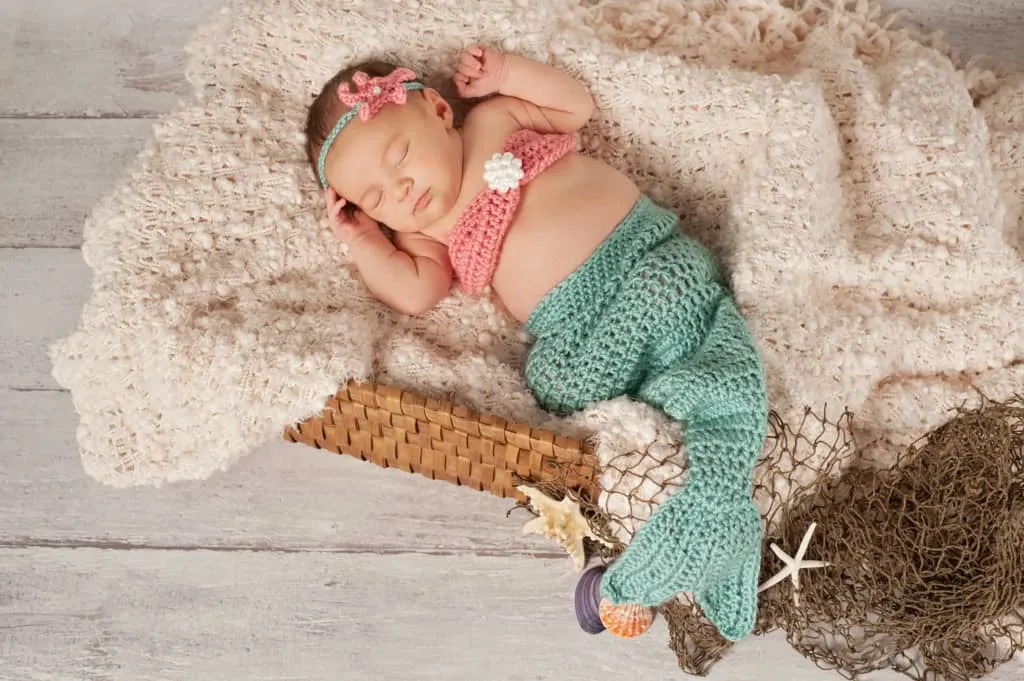 Infant girl in crochet mermaid costume with name from mermaid baby names list.