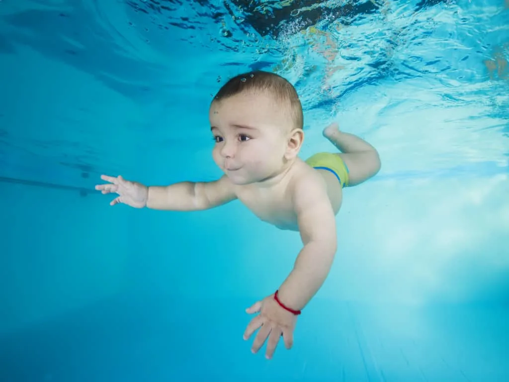 Baby boy learns to swim.