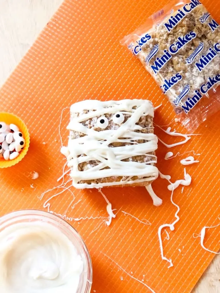 Mummy Cake Halloween snack idea next to frosting and edible eyes.