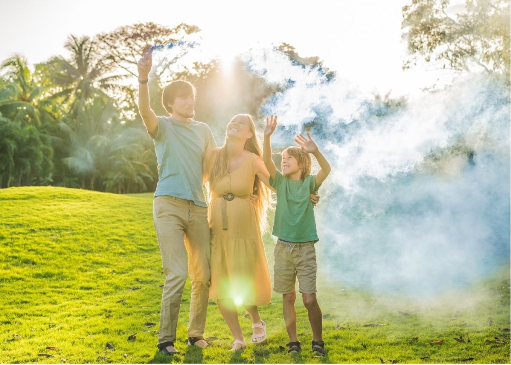 A family surrounded by blue smoke outside.