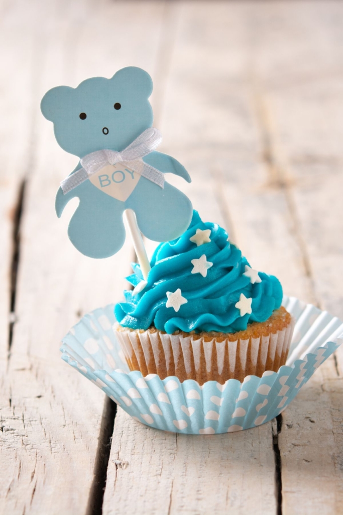 A blue cupcake with a blue teddy bear.