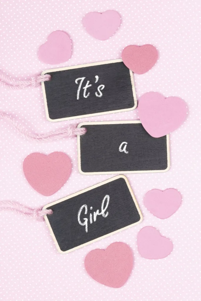 It's a girl spelled out on mini chalkboard signs surrounded by paper hearts.