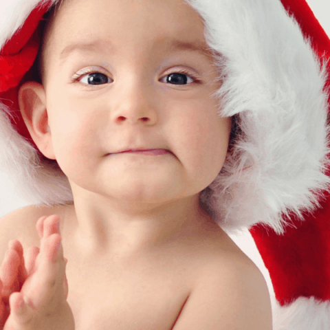 Baby wears Christmas hat meant for stocking stuffers for babies.
