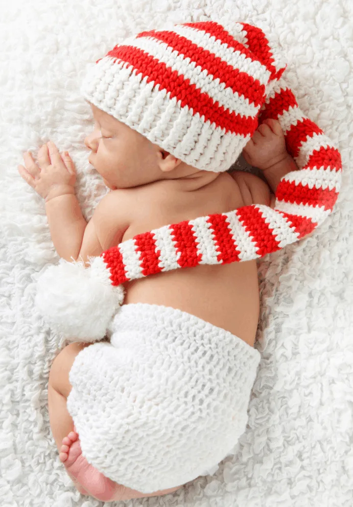 Baby's first Christmas newborn photo with crochet hat.