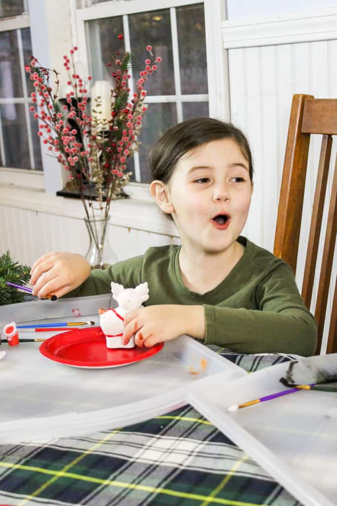happy girl laughing while painting christmas ornament
