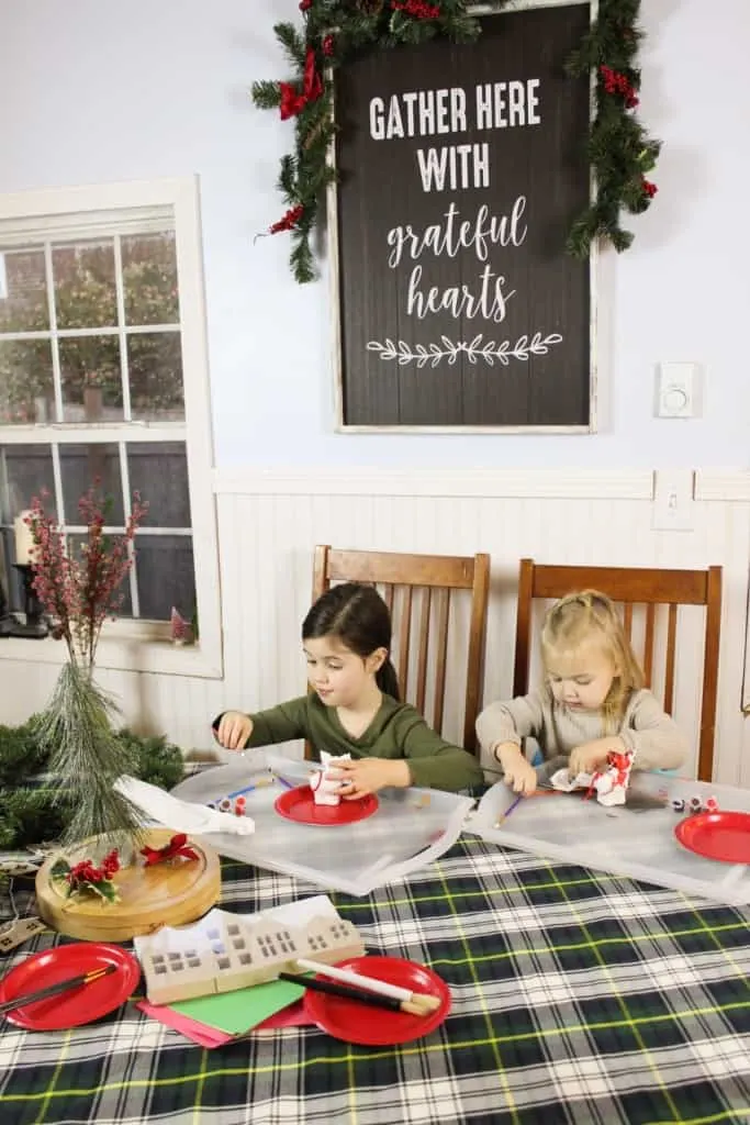 Two girls doing Christmas arts and crafts at a table.