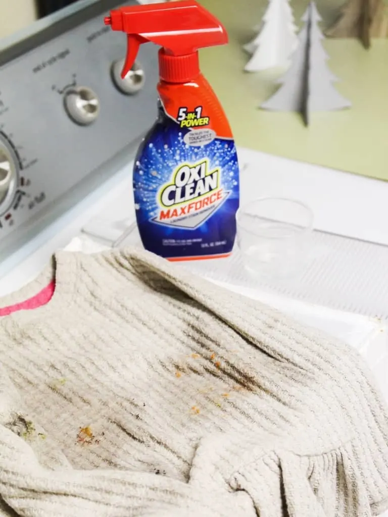 stained shirt with bottle of oxi clean max force spray and detergent