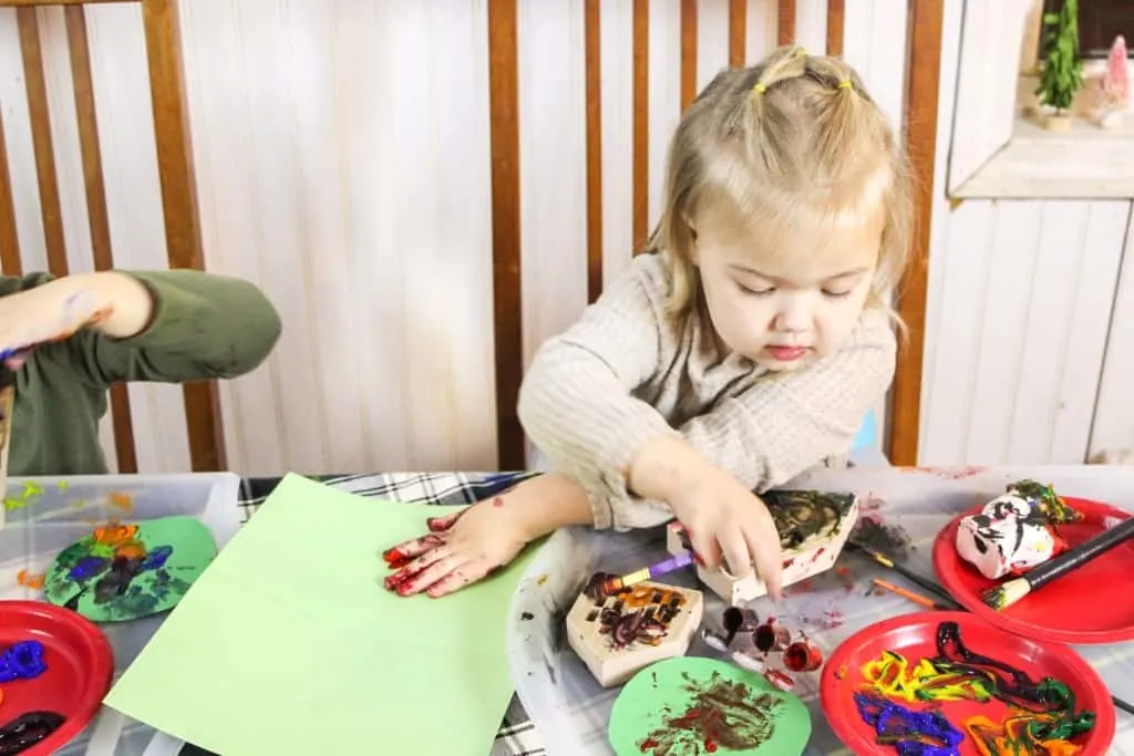 Little girl doing Christmas crafts at a table.