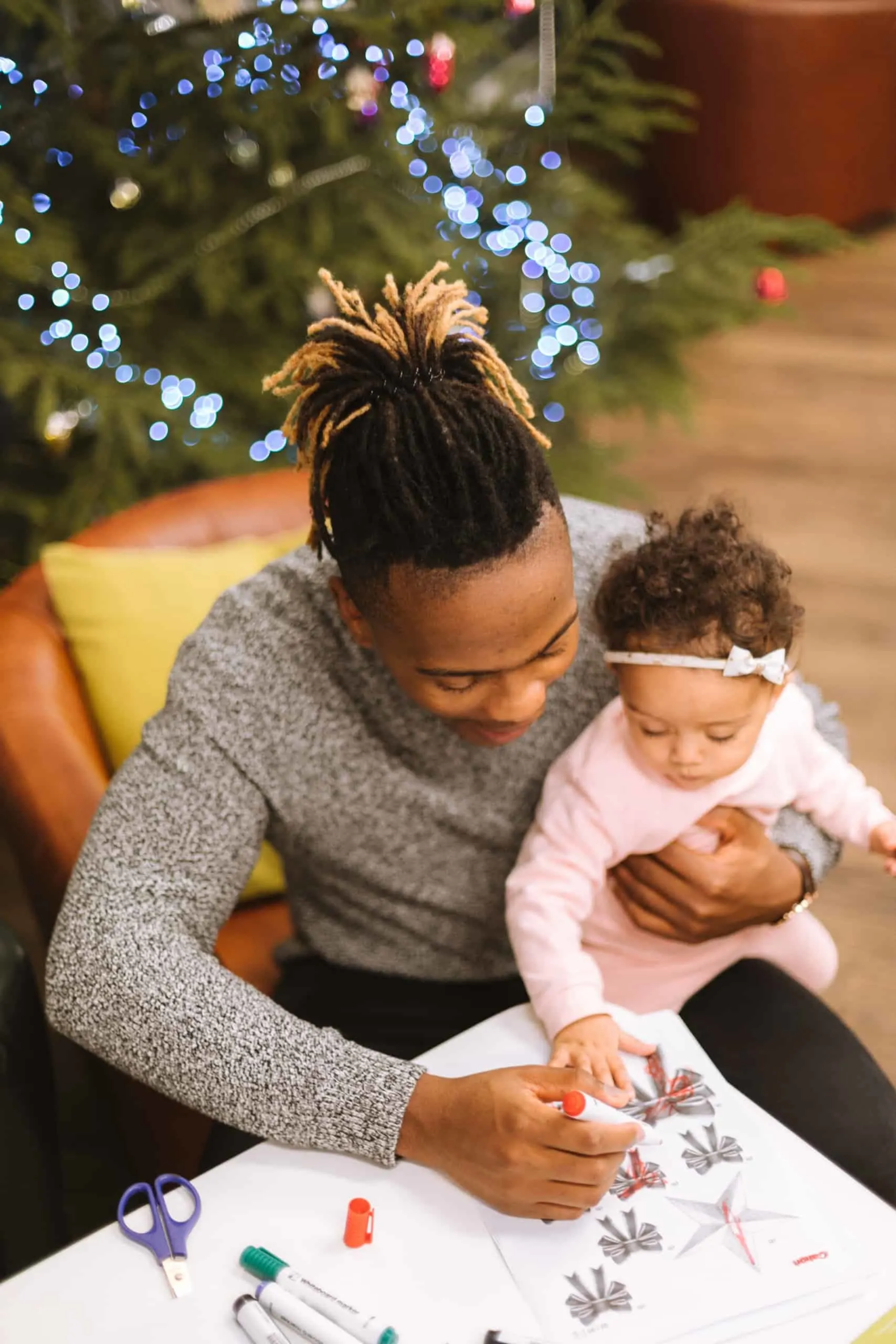 father with daughter coloring for baby's first christmas