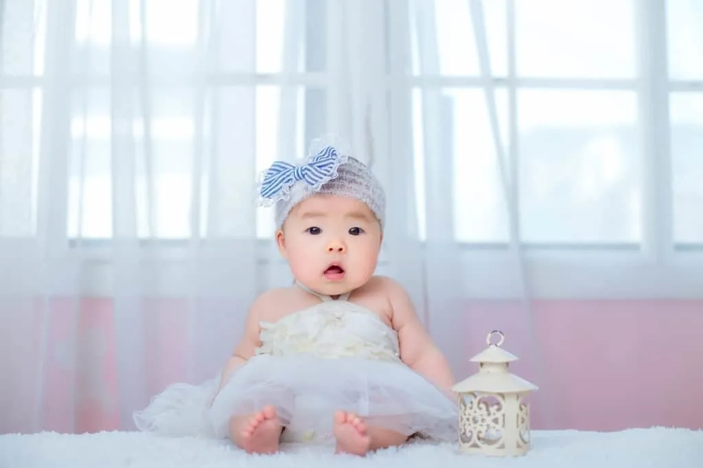 Baby girl in tutu dress poses for camera.