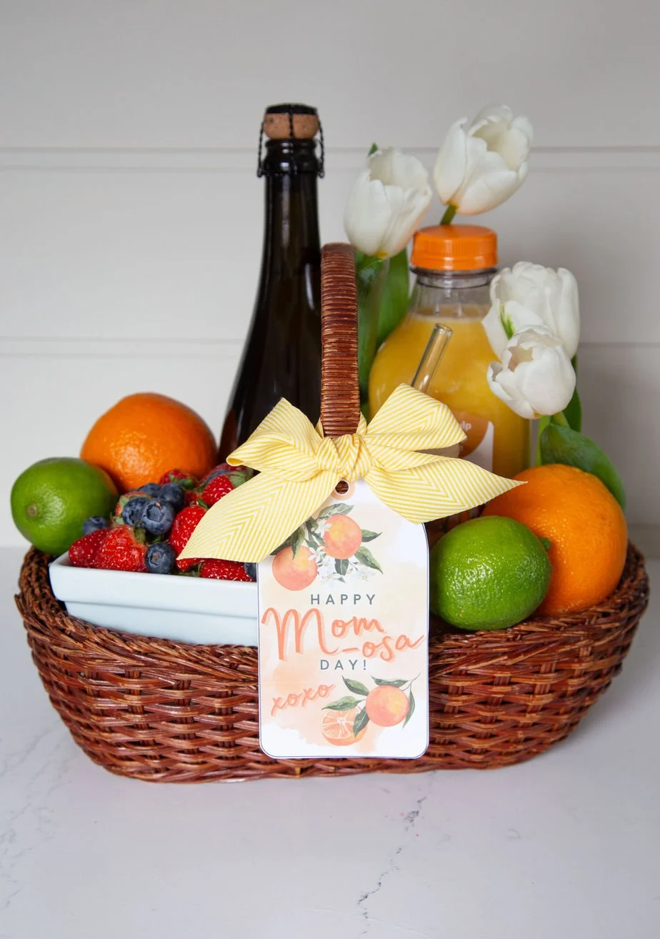 Mimosa-themed gift for moms with orange juice and fresh oranges.