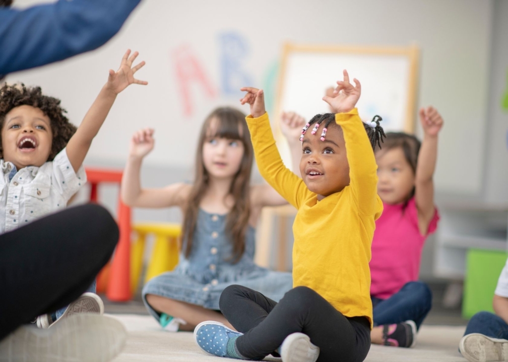 Kids play a circle time activity.